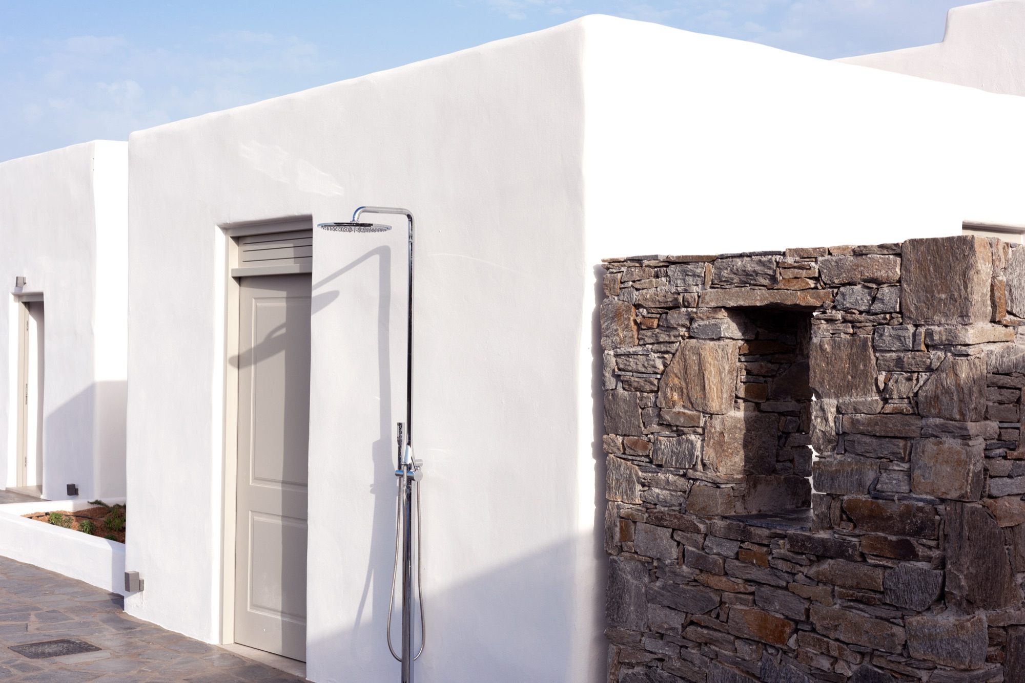 The outdoor shower against the whitewashed wall